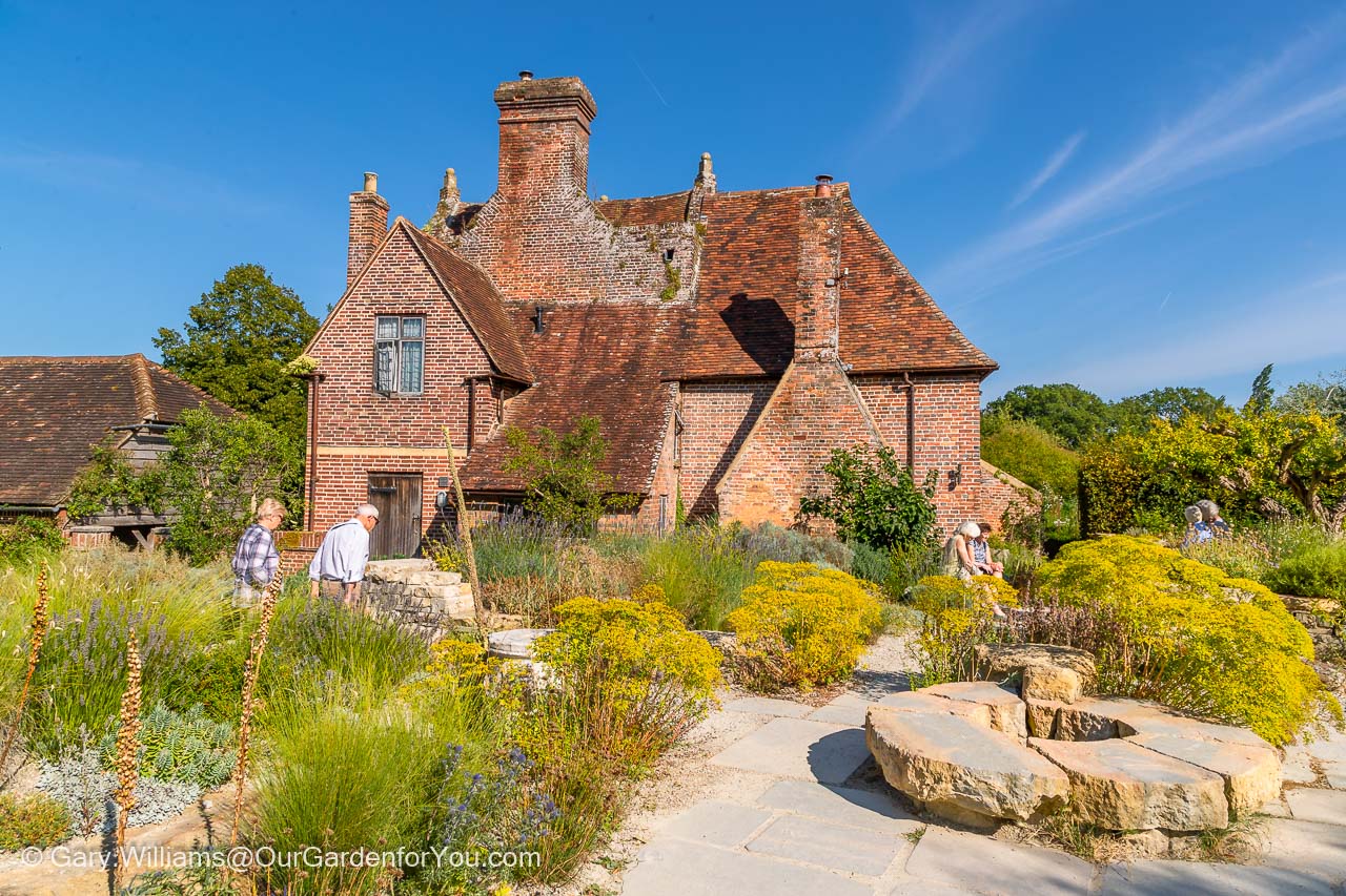 A view of the Elizabethan Priest’s House with the planting of the Mediterranean themed Delos Garden at Sissinghurst Castle Garden