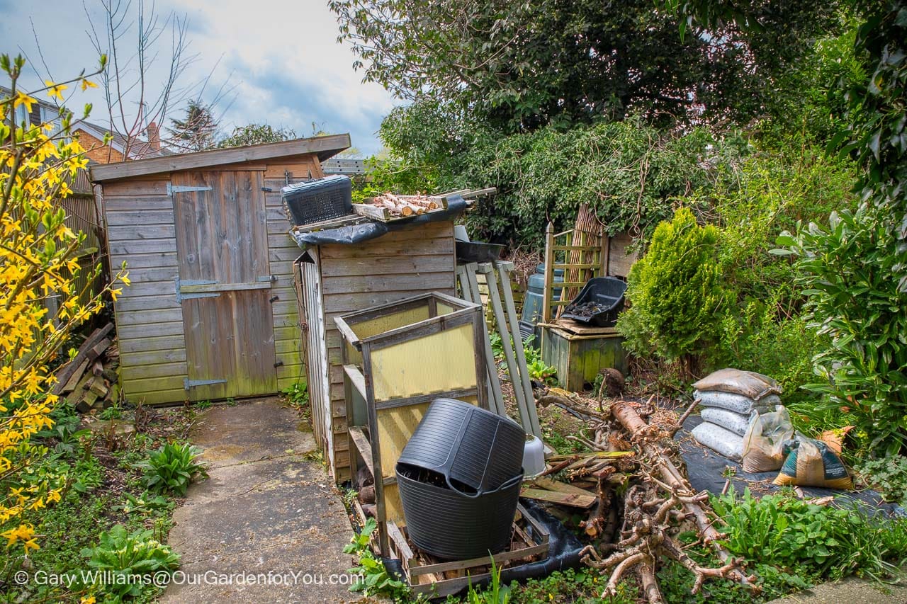 A path leads to the potting shed and tool store in the working area of the garden.