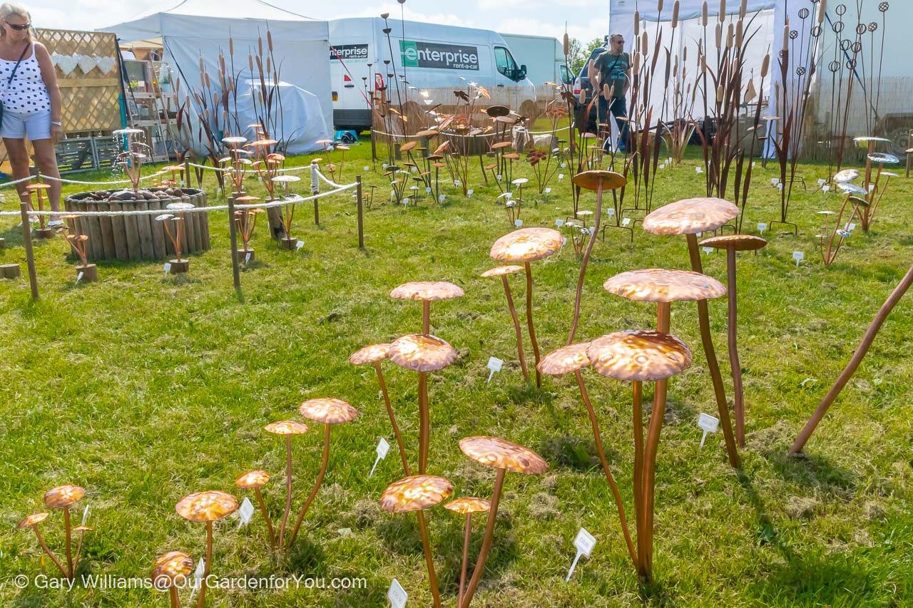 A display of copper mushrooms on a stand at the Kent Garden Show