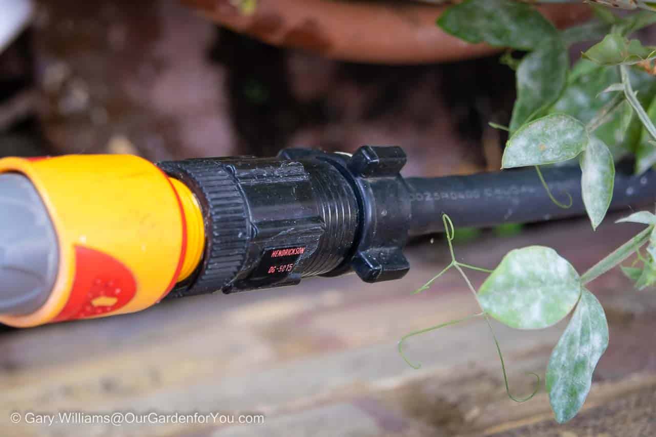 A hosepipe connected to Hozelock's Pressure Regulator connected to the supply tube of our home irrigation system