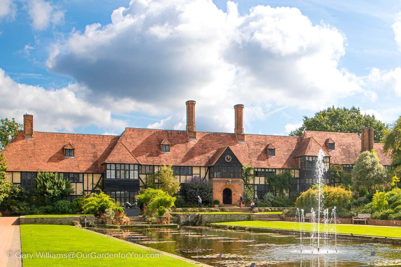 The red brick Arts and Crafts Wisley Laboratory in the RHS Garden Wisley at the end of the Jellicoe Canal