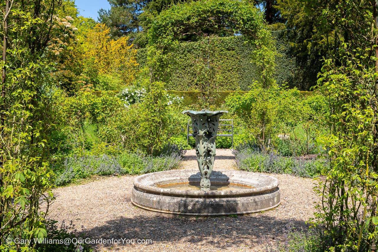 An ornate bronze water fountain takes centre stage in the rose garden at nymans in west sussex