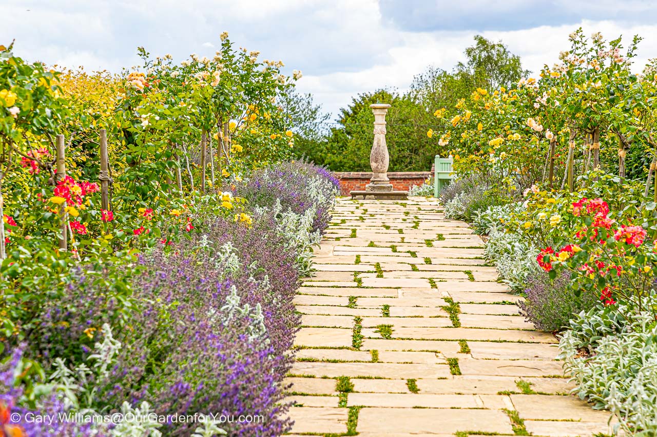The stone path leading to a sundial at the centre of golden rose avenue in the walled garden in the chartwell estate in kent