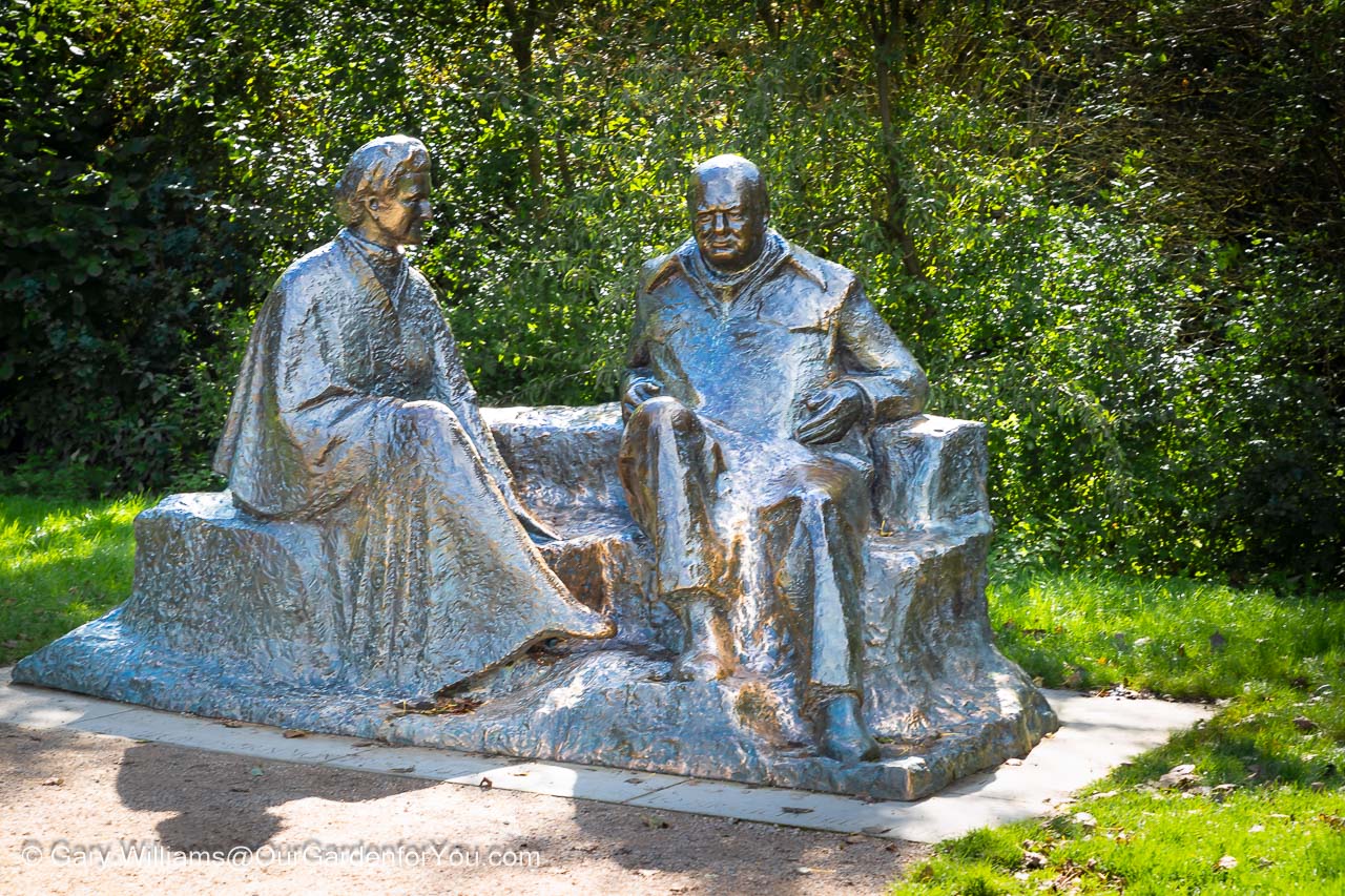 A lifesize bronze statue of Sir Winston Churchill and his wife Lady Clementine Churchill sitting on a bench in the grounds of Chartwell.